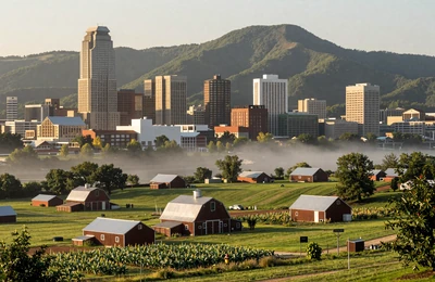 Knoxville Tennessee with Great Smoky Mountains rising behind green foothills dotted with family farms and tobacco barns