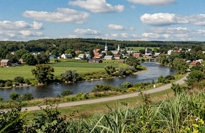 Bangor Maine area with the Penobscot River winding through green farmland and forest hills with church steeples