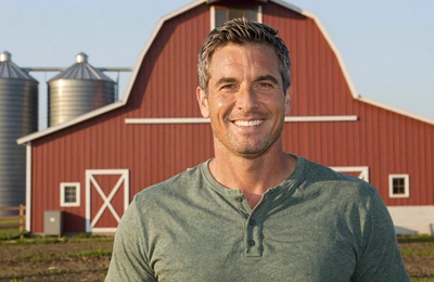Robert a 52-year-old successful grain farmer standing near modern silos on his Illinois operation