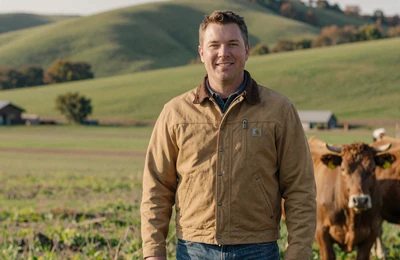 Liam a 45-year-old Irish-heritage cattle rancher from Indiana standing in his green pasture with Angus cattle